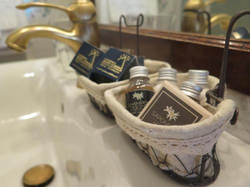 a basket on a bathroom sink with soap and a mirror at Chambres Mont Cervin in Breuil-Cervinia