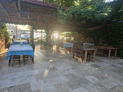 a patio with tables and chairs under a pergola at Kalimerhaba Motel Restaurant in Gokceada Town