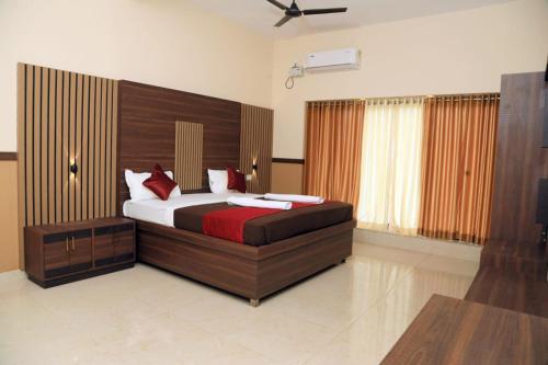 a bedroom with a large bed with red pillows at Bekal Eden Resorts in Kāsaragod