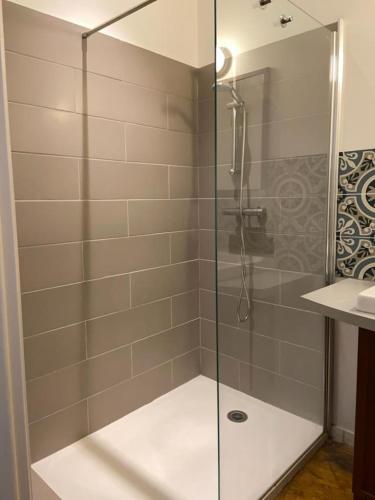 a shower with a glass door in a bathroom at Furnished T2 apartment in Luchon