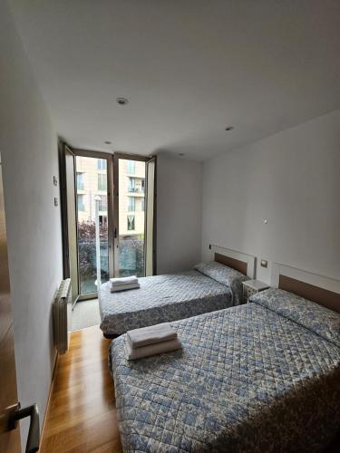 a room with two beds and a window at Os limoeiros do cura in Foz
