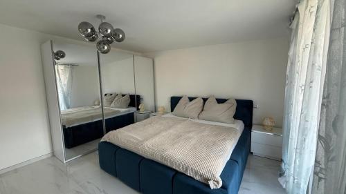 a bedroom with a blue bed and a mirror at Laguna Blu in Montepaone Lido