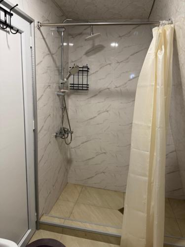a shower with a shower curtain in a bathroom at Cloudtop House - Gomismta in Gomi