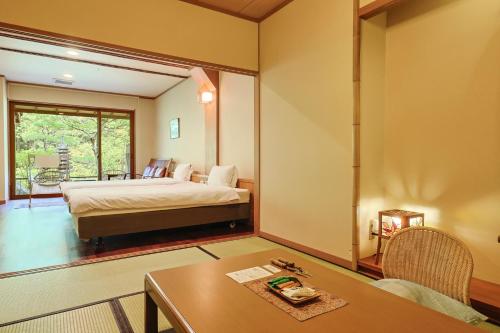 a bedroom with a bed and a table in a room at Yumenoian Yuyake Koyake in Himeji
