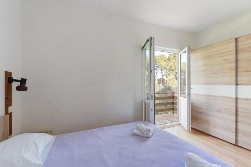 a bedroom with a bed and a large window at Apartman Viola 1 in Ugljan