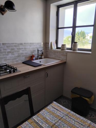 a kitchen with a sink and a stove at La Grange de Campaulise - Camping à la ferme - Hébergements - Mont Ventoux in Mazan