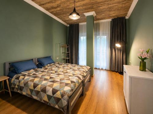 a bedroom with a bed in a room with green walls at Apartment MILU in Mestia