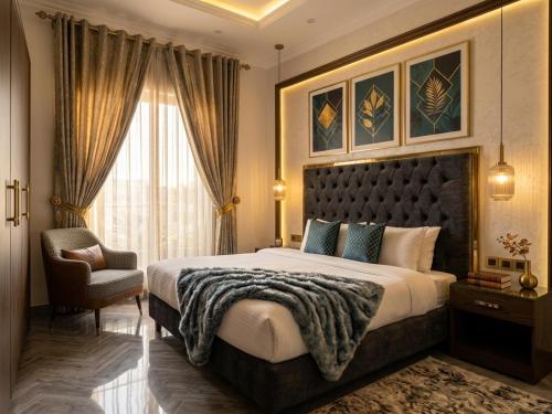 a bedroom with a large bed and a chair at Regency Suite Hotel in Lahore
