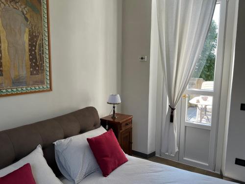 a bedroom with a bed with red and white pillows at Villa Rosazza in San Salvatore Monferrato