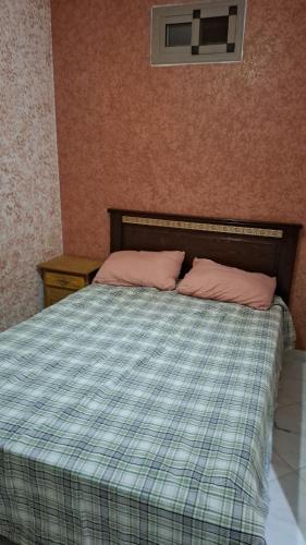 a bed with two pink pillows in a bedroom at Belle apt près de la mer in Tangier