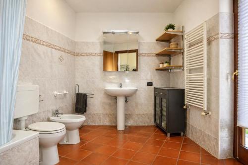 a bathroom with a toilet and a sink and a mirror at Shila House in Luino
