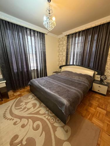 a bedroom with a bed and a chandelier at Большой дом в Степанаване in Stepʼanavan