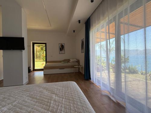a bedroom with a large window with a view of the ocean at Sebi's Chalet with Sea View in Vlorë