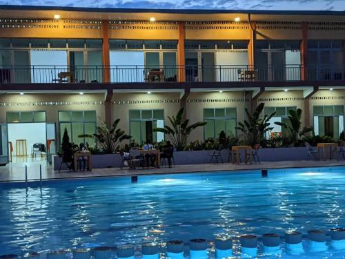 a hotel with a swimming pool in front of a building at Chris Hotel in Runda