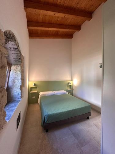 a bedroom with a green bed in a room at Casal Sikelio in Cassibile