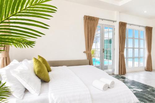 a bedroom with a white bed with towels on it at Luxury Pool Villa Pattaya Center C3- 3 Bedroom in Pattaya South