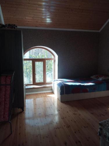 a bedroom with a bed and an open window at İsmayıllı bağ evi in İkinci Yeniyol
