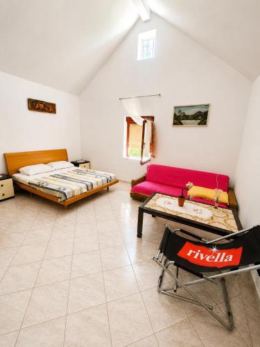 a bedroom with a bed and a couch and a table at Holiday home Moni in Karlobag