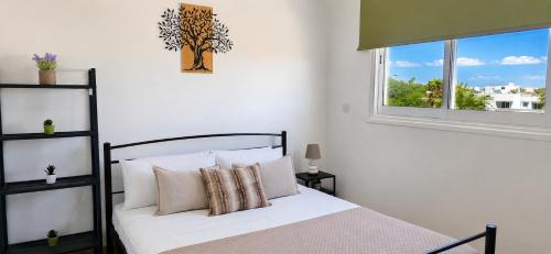 a bedroom with a bed with pillows and a window at Carisa Lighthouse by Staycom in Perivolia