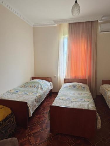 a bedroom with two beds and a window at House Dea Dea in Chakvi