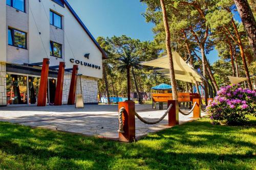 a building with a hammock in the grass next to a building at Columbus Rowy in Rowy