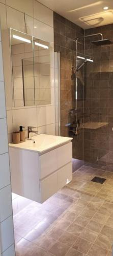 a bathroom with a sink and a shower at Apartment Sollid - Your comfortable accommodation in Huskvarna