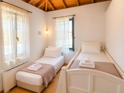 a room with two beds and a window at Aeolian Garden in Mytilene