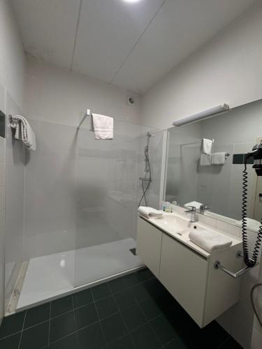 a white bathroom with a shower and a sink at Hobbit Hotel Brussels Airport Zaventem in Zaventem