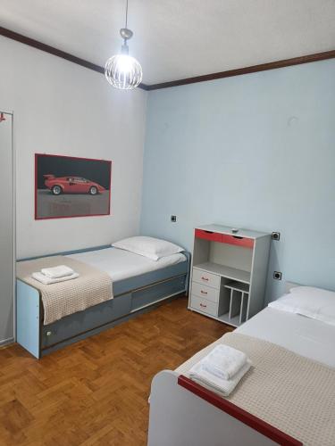 a bedroom with two beds and a car picture on the wall at Villa Orfani in Orfánion