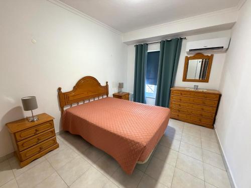 a bedroom with a bed and a dresser and a mirror at Casa Canoa B in Armação de Pêra