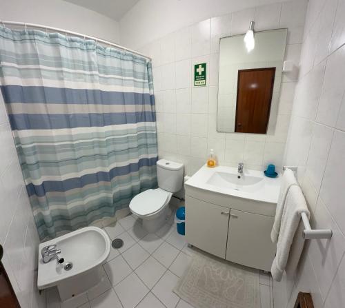 a bathroom with a sink and a toilet and a mirror at Casa Canoa B in Armação de Pêra
