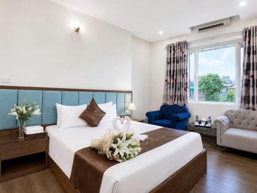 a bedroom with a large bed with a blue headboard at Ho Sen Xanh Hotel in Hanoi