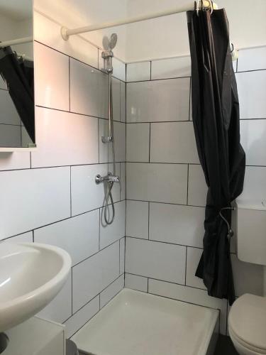 a bathroom with a shower with a sink and a toilet at FEWO Turf Watt Nr.5 in Cuxhaven