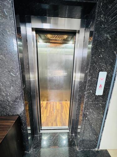 an elevator in a building with a wooden floor at Sofra service apartment by LUXE with swinging pool in Mysore