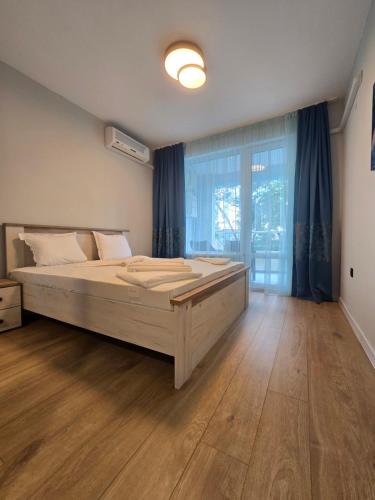 a bedroom with a large bed and a large window at Yassen Holiday Village in Sunny Beach