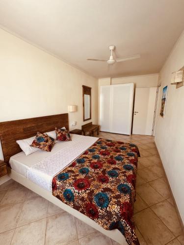 a bedroom with a bed with a quilt on it at Tropisal Apartamento in Santa Maria