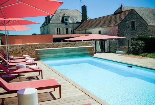 - une piscine avec 2 chaises longues et 2 parasols dans l'établissement Castel de Très Girard - Hotel & Restaurant - Teritoria, à Morey-Saint-Denis