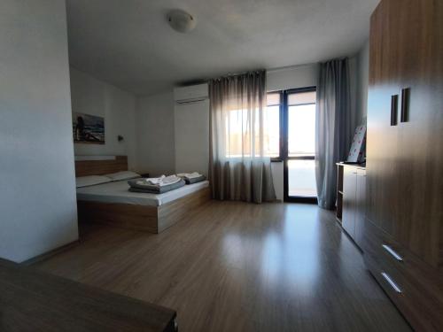 a large room with a bed and a window at Yanevi Apartments in Chernomorets