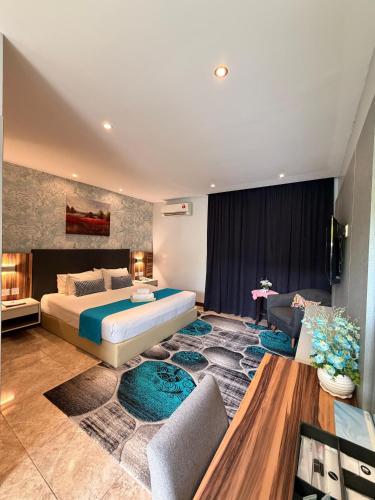 a bedroom with a king sized bed and a couch at Villa Abadi Resort VAR in Pantai Kok