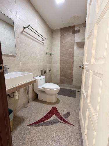 a bathroom with a toilet and a sink and a door at Villa Abadi Resort VAR in Pantai Kok