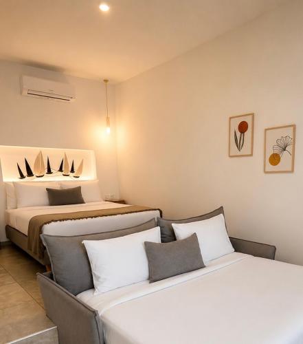 two beds in a room with two beds at MykoNest in Agios Stefanos