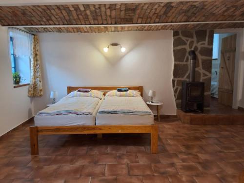 a bedroom with a bed and a stone wall at Apartmán Štrobl in Borovany