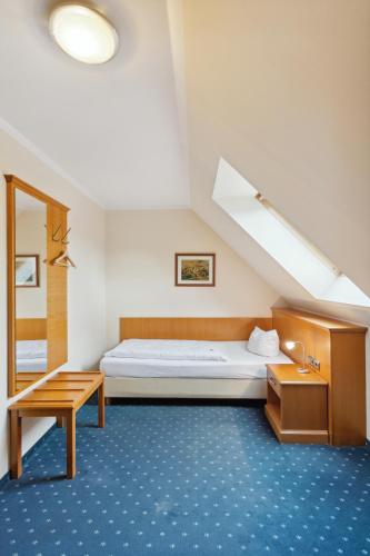 ein Zimmer mit einem Bett, einem Tisch und einem Fenster in der Unterkunft Hotel Blaue Ecke in Adenau