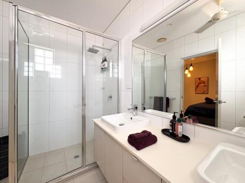 a white bathroom with a sink and a shower at The Skyline Lookout Pool, BBQ, FREE parking in Stuart Park