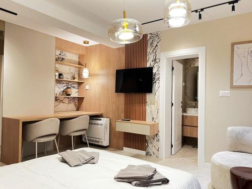 a room with a bed and a desk and a tv at Villa Harmonia in Glavati