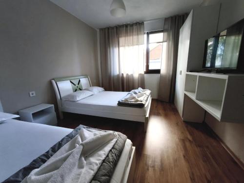 a hotel room with two beds and a window at Yanevi Apartments in Chernomorets