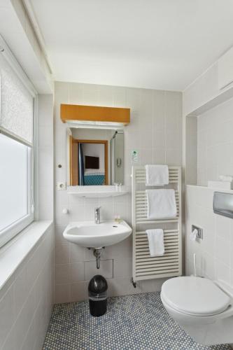 ein weißes Badezimmer mit Waschbecken und Toilette in der Unterkunft Hotel Blaue Ecke in Adenau