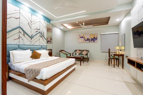 a bedroom with a bed and a table and chairs at Hotel Leela Grande in Karnāl
