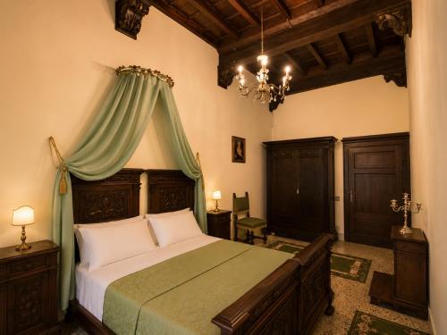 a bedroom with a large bed with a green canopy at All'Ombra della Torre a due passi da Piazza del Campo in Siena