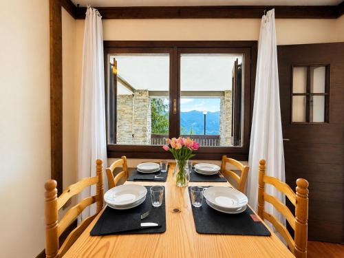 a dining room with a table and a window at Hostdomus - B3-03 in Grange Sises